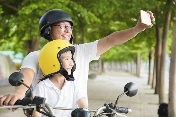 Pai e filha viajando e tomando selfie na motocicleta — Fotografia de Stock