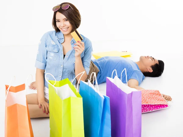 Feliz jovem casal com sacos de compras e cartão de crédito — Fotografia de Stock