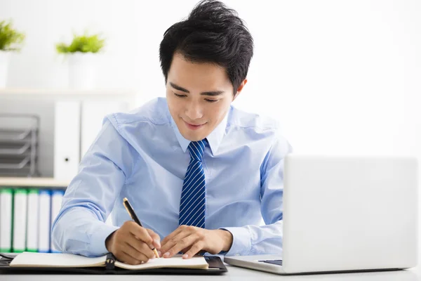 Lachende jonge zakenman, werkzaam in het kantoor — Stockfoto