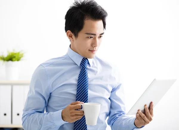 Lachende jonge zakenman lezen op de tablet — Stockfoto