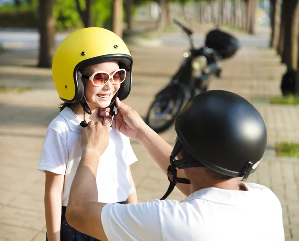 Pai tentando usar um capacete de bicicleta para sua filha — Fotografia de Stock