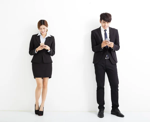 Joven hombre y mujer de negocios sosteniendo el teléfono inteligente — Foto de Stock