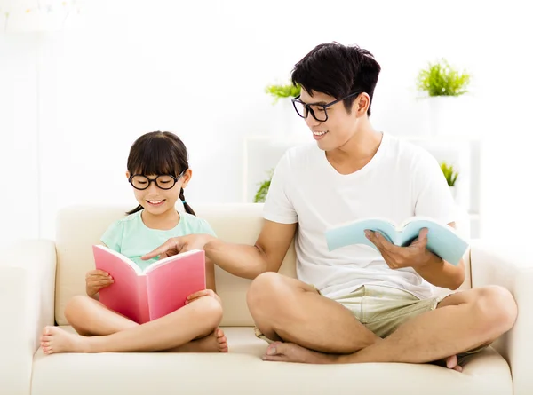 Father and daughter studying together on sofa — Stock Photo, Image