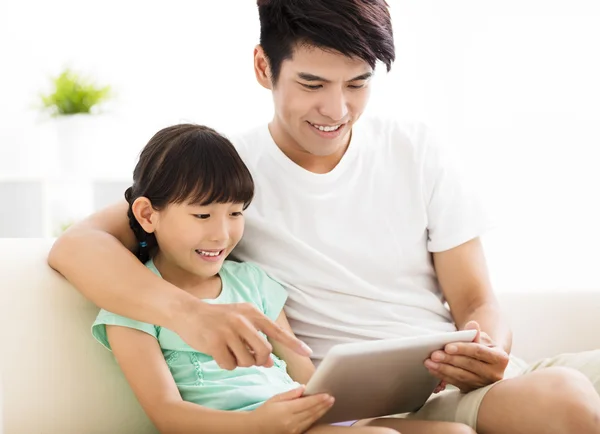 Ayah dan anak yang bahagia menggunakan tablet di sofa — Stok Foto