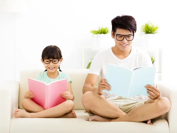 Otec a dcera studuje společně na pohovce — Stock fotografie