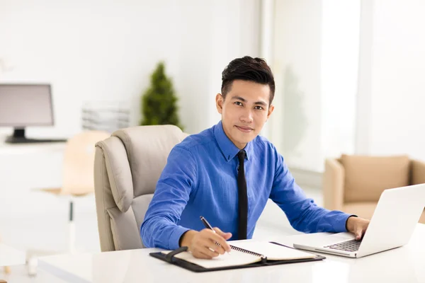 Jeune homme d'affaires souriant travaillant dans le bureau — Photo