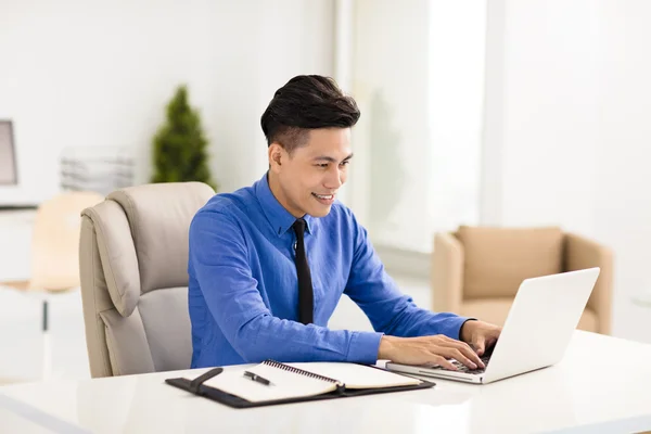 Jonge lachende zakenman, werkzaam in kantoor — Stockfoto