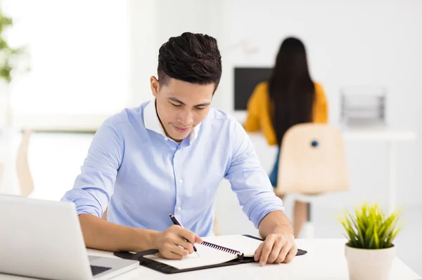 Jeune homme d'affaires souriant travaillant dans le bureau — Photo