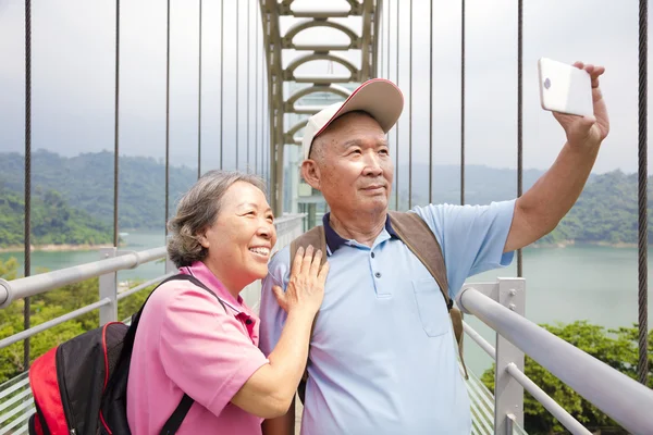 Feliz pareja de ancianos tomando fotos con selfie teléfono inteligente —  Fotos de Stock