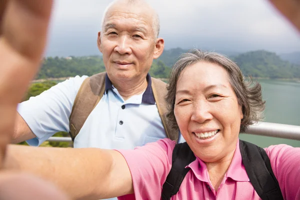 Щаслива старша пара робить фотографії з розумним телефоном селфі — стокове фото