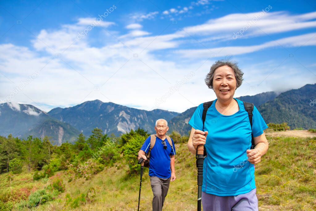 Asian Senior  couple hiking on the beautiful mountains