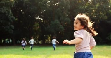 Çimlerin üzerinde koşan ilkokul öğrencilerinin arka camı