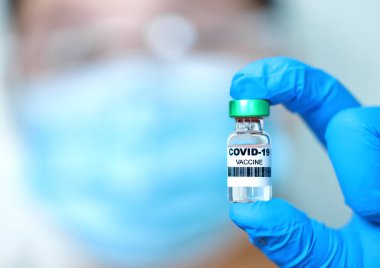 Coronavirus aşısı geliştirme ve yaratma COVID-19 konsepti. Doktor elinde aşı olduğunu gösteriyor.