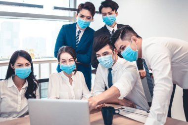 Modern ofiste yüz maskesi takan ve iş görüşmeleri yapan işadamları virüs salgını sırasında