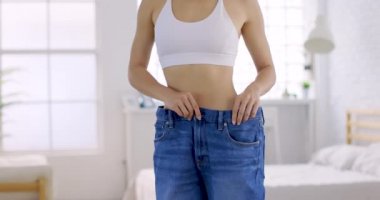 Büyük kotlu genç, sıska kadın evde diyet sonuçlarını gösteriyor.