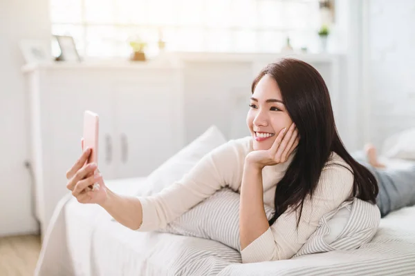 Glad Ung Kvinna Använder Videosamtal Mobiltelefon Och Ligger Sängen — Stockfoto