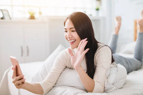 Glad Ung Kvinna Använder Videosamtal Mobiltelefon Och Ligger Sängen — Stockfoto