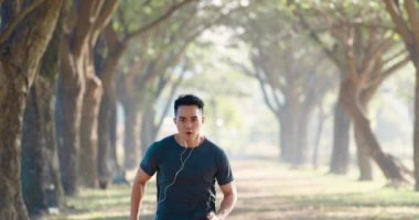  Genç adam sabah sisli bir havada şehir parkında koşuyor.