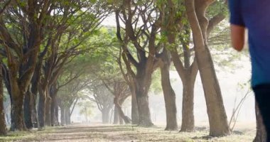 Delikanlının sisli bir havada ormanda koşarkenki görüntüsü.