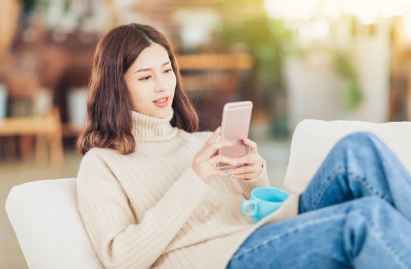 Menina Sentada Sofá Com Xícara Café Chá Assistir Smartphone — Fotografia de Stock