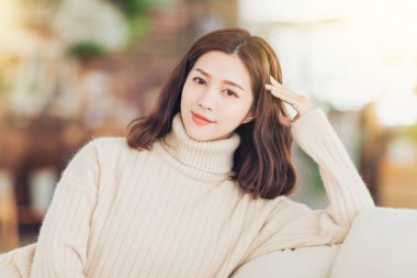 Kışın evdeki kanepede rahat genç bir kadın oturuyor.