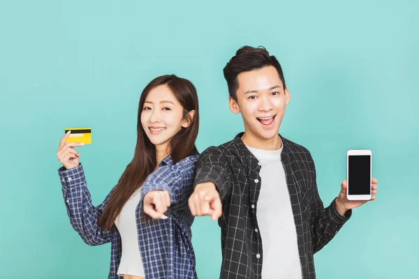 携帯電話とクレジットカードを示す幸せなアジアの若いカップル — ストック写真