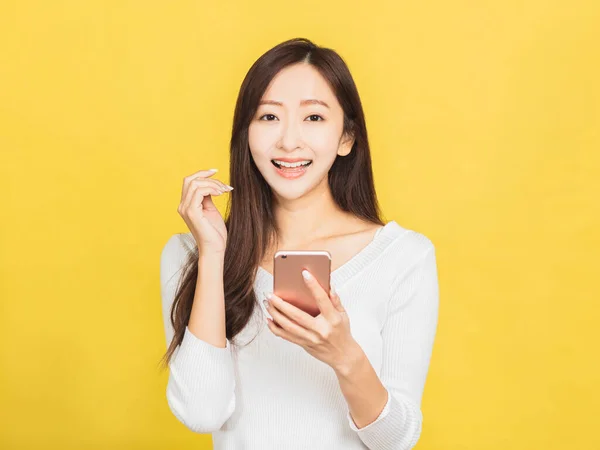 笑顔のカジュアルな若い女性がスマホを — ストック写真