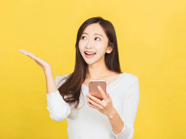 Sonriente Mujer Joven Casual Sosteniendo Teléfono Inteligente Mirando Lado —  Fotos de Stock