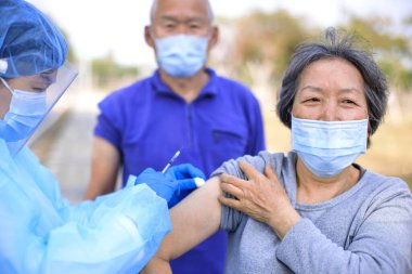 Doktor yaşlılara kovid 19 aşısı yapıyor.