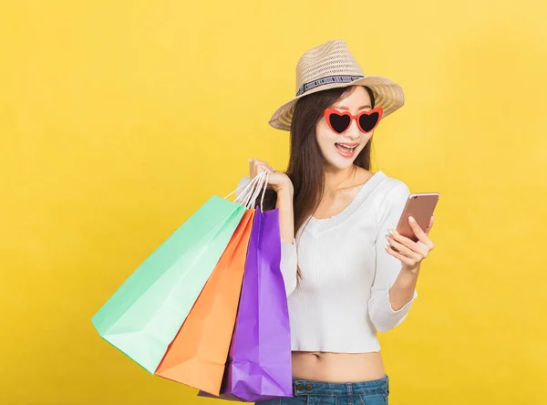 Alışveriş Torbaları Tutan Cep Telefonunu Izleyen Mutlu Genç Bir Kadın — Stok fotoğraf