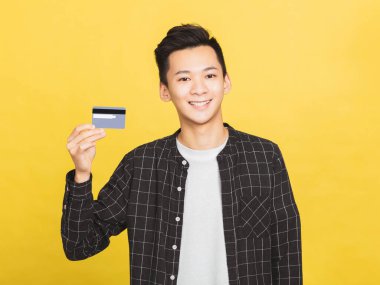 Genç adam kredi kartını gösteriyor.