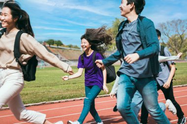 Sahada koşuşturan mutlu genç grup öğrencileri