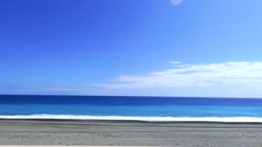 POV-Yolcu yan pencere sürüş sahnesi. Mavi gökyüzüne karşı mavi okyanus