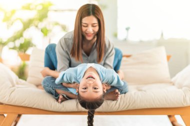  Mutlu anne ve kız kanepede oynuyor ve gülüyor.