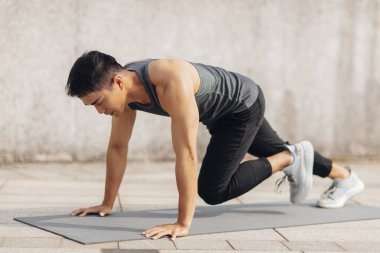 Yakışıklı sporcu dışarıda antrenman yapıyor.