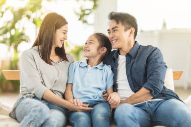 Mutlu aile evde kanepede gülümsüyor ve sarılıyor.