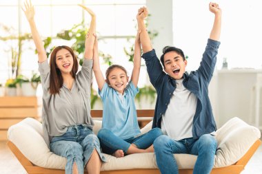  Mutlu aile evdeki koltukta el kaldırıyor.