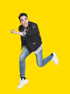 Heyecanlı, sıradan kıyafetlerle atlayan yakışıklı bir genç.