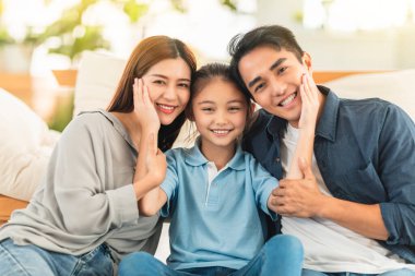 Mutlu aile evde kanepede gülümsüyor ve sarılıyor.