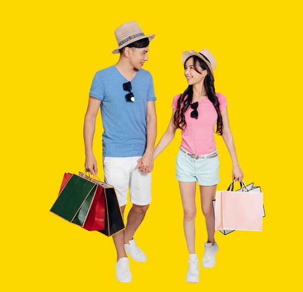 幸せな若いカップル歩くとショッピングバッグを保持 — ストック写真