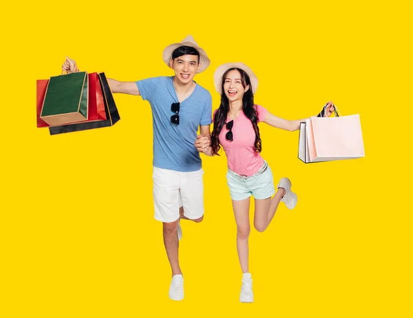 Happy Young Couple Jumping Holding Shopping Bags — Stock Photo, Image