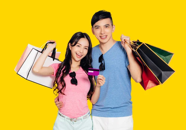 クレジットカードやショッピングバッグを見せる若いカップル — ストック写真