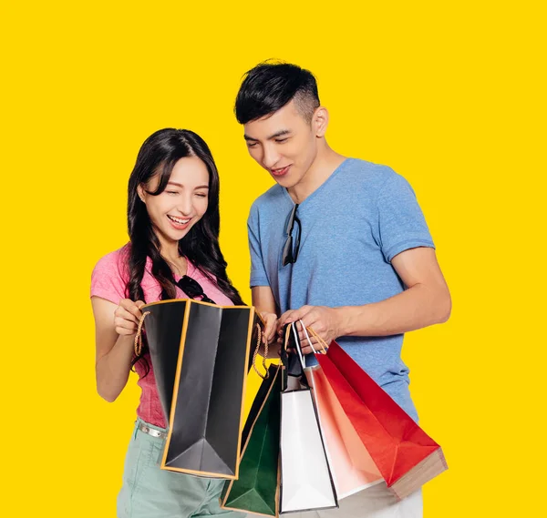 幸せな若いカップル見ザギフトでショッピングバッグ — ストック写真