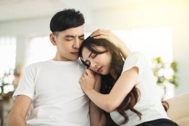 Depresyondaki genç kadın ağlarken erkek arkadaşı gelip onu kucaklıyor.