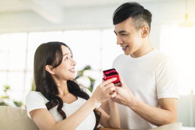 Genç adam evde hediyesiyle kız arkadaşına sürpriz yapıyor..