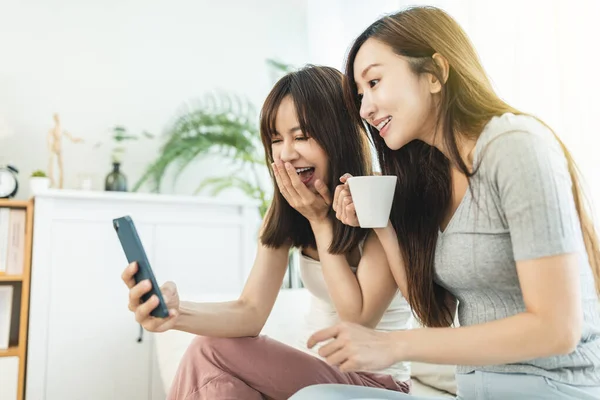 Två Rumskamrater Använder Sina Smarta Telefoner Sittandes Soffa Hemma — Stockfoto