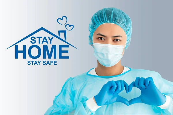 Doctor wear face mask, gloves, blue green uniform showing heart hands shape and stay home concepts