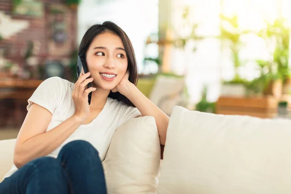 Ung Kvinna Sitter Soffan Hemma Håller Telefonen Och Diskuterar Arbete — Stockfoto