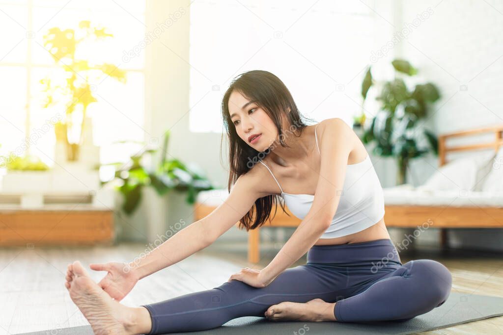 young woman  wearing casual sports clothing, exercises at home every day,  stretch exercises, yoga, fitness