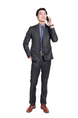 Genç yakışıklı işadamı ayakta duruyor ve telefonda konuşuyor.. 